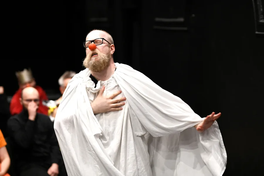 A performer spreading a white costume out like wings.